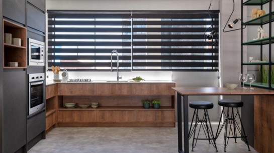 Uma bancada ampla, nichos, estantes e uma mesa alta para as refeições são algumas das soluções pensadas para este loft assinado pela Criare Persone Bento Gonçalves. Foto: Roberta Gewehr